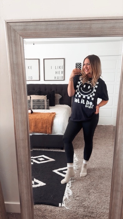 Danielle, founder of the Bestie Squad, in a checkered smiley "let it be, bestie" t-shirt.