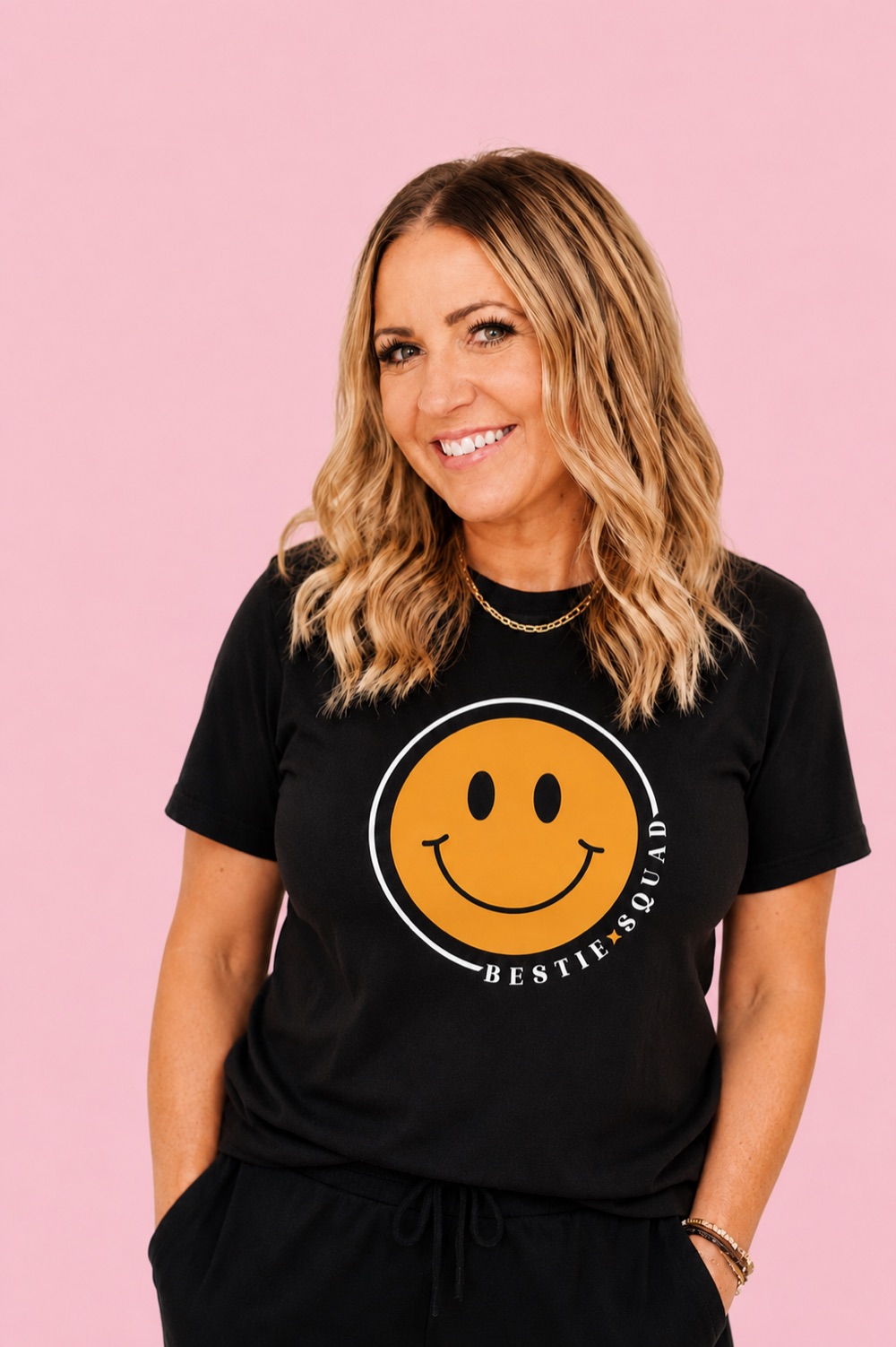 Danielle, founder of the Bestie Squad, wearing a black Bestie Squad t-shirt with the yellow smiley logo.