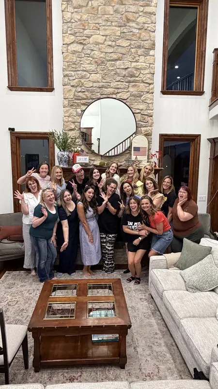 Bestie Squad women gathered in a living room, smiling for a group photo.
